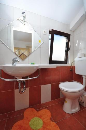 a bathroom with a sink and a toilet and a mirror at Apartments by the sea Vela Luka, Korcula - 9243 in Vela Luka
