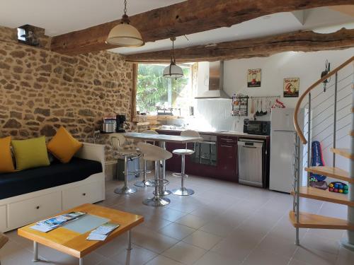 un salon avec un canapé et une cuisine dans l'établissement Gîte Le Valet, T2 classé 3 étoiles, entre Rennes et Saint-Malo, à La Chapelle-aux-Filzméens