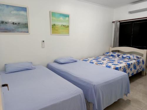 a room with two beds and a window at Ap 2 quartos suite wifi 30m da praia in Guarujá