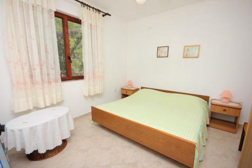 Schlafzimmer mit einem Bett, einem Tisch und einem Fenster in der Unterkunft Apartment Mala Lamjana 827b in Kali