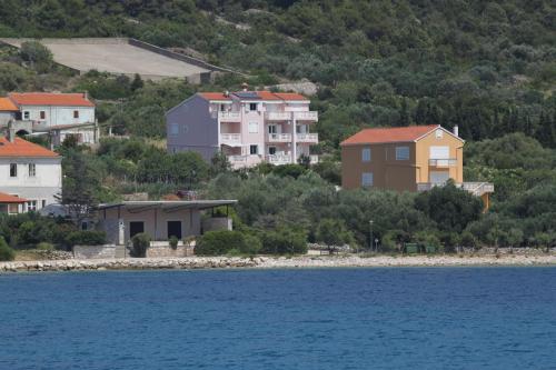 un groupe de maisons sur une colline à côté de l'eau dans l'établissement Apartments and rooms by the sea Cove Soline, Dugi otok - 448, à Veli Rat