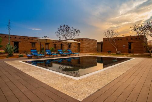 una piscina en un patio con sillas azules alrededor en Casa Regina Oaxaca en San Pablo Villa de Mitla
