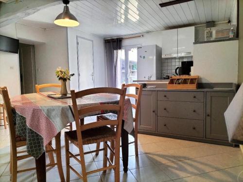 une cuisine avec une table et des chaises et une cuisine avec un comptoir dans l'établissement Gîte familial à la ferme avec jardin clos, proche Forêt d'Orléans et étangs, lits faits, jeux enfants - FR-1-590-88, à Vieilles-Maisons-sur-Joudry