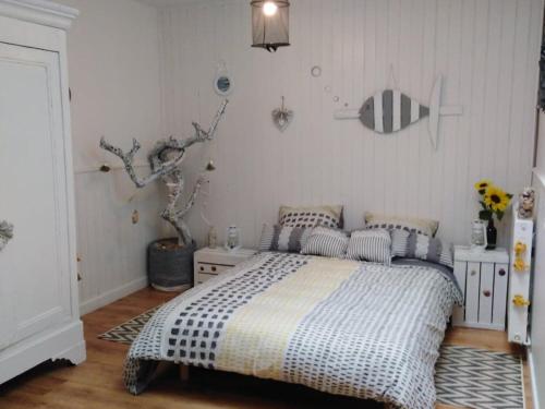 a bedroom with a bed with a black and white comforter at Gîte L'Hermenault, 8 pièces, 14 personnes - FR-1-426-362 in LʼHermenault