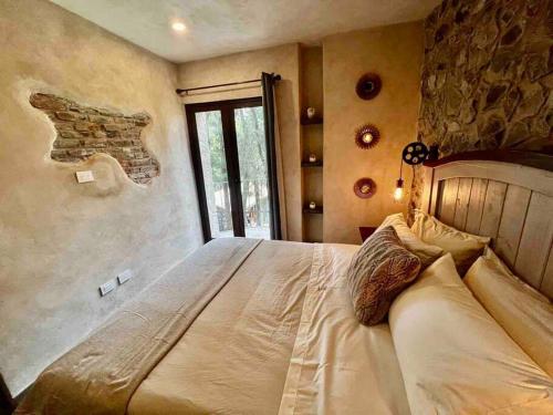 a bedroom with a large bed with a stone wall at Increíble Loft Completo en Val'Quirico in Santeagueda