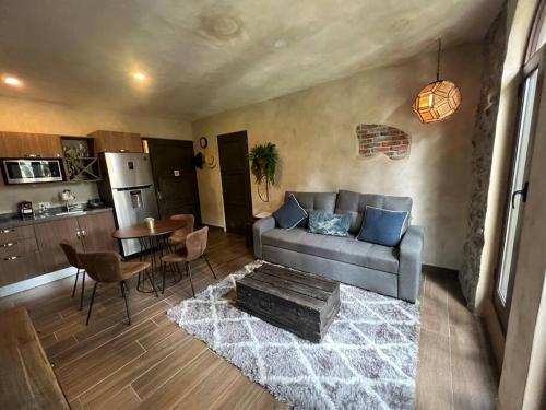 ein Wohnzimmer mit einem Sofa und einem Tisch in der Unterkunft Increíble Loft Completo en Val'Quirico in Santeagueda