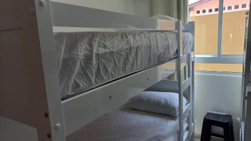 a bunk bed in a small room with a ladder at Apartamento Pé na areia em Tamandaré-Porto Cayman in Tamandaré