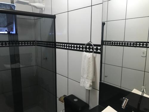 a black and white bathroom with a shower and a towel at Loft para locação em Calheiros Governador Celso Ramos in Governador Celso Ramos