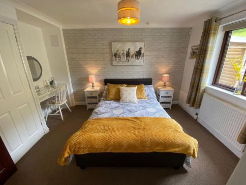 a bedroom with a large bed with a yellow blanket at Highbury House in Camborne