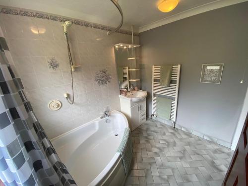 a bathroom with a tub and a sink at Highbury House in Camborne
