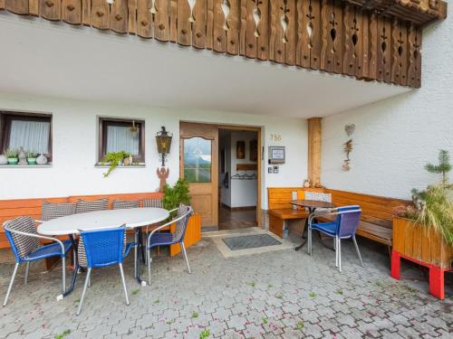 un patio con mesa y sillas y un edificio en Vintage Holiday Home in Vorarlberg near Ski Area, en Schwarzenberg im Bregenzerwald