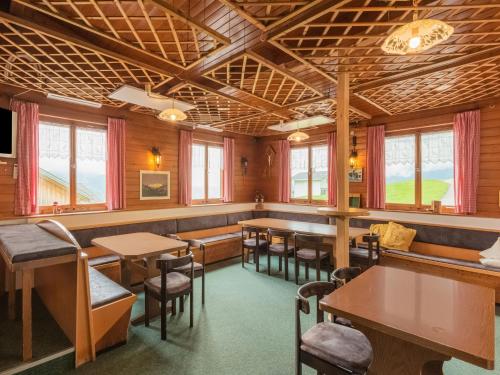 a restaurant with tables and chairs and windows at Vintage Holiday Home in Vorarlberg near Ski Area in Schwarzenberg im Bregenzerwald