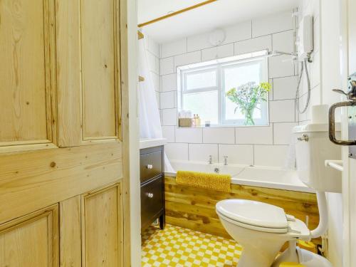 a bathroom with a toilet and a tub and a sink at Angel Lane in Woodbridge