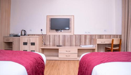 a hotel room with two beds and a television at Drishya Hotel in Kathmandu