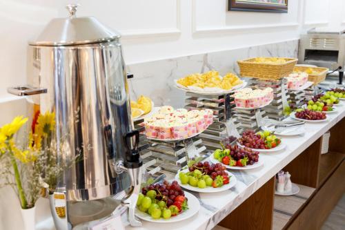 een buffet met veel schalen fruit en gebak bij Wisteria Hotel Dalat in Da Lat
