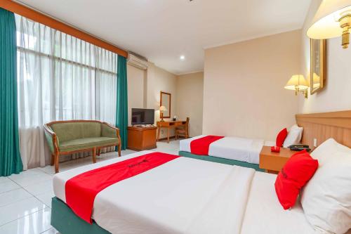 Habitación de hotel con 2 camas y TV en RedDoorz Plus near Kemang Raya, en Yakarta