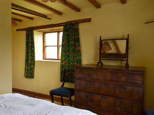 ein Schlafzimmer mit einer Kommode und einem Fenster in der Unterkunft Cider Mill in Berrington