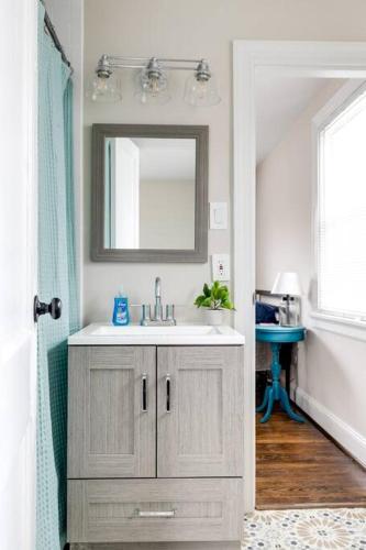 a bathroom with a sink and a mirror at RVA Cottage Cozy & Spacious Near Downtown in Richmond