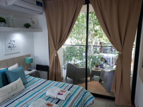 um quarto com uma cama e uma grande janela em Departamento Vera Mujica 3 cochera propia incluida em Rosário