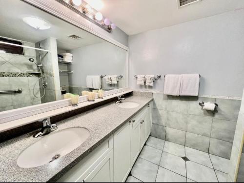 a bathroom with two sinks and a large mirror at Sapphire Beach-Beachfront Condo SALE - View of Paradise in East End