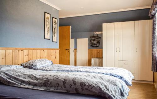 two beds in a bedroom with blue walls at Cozy Home In Etne With Wifi in Etnesjøen