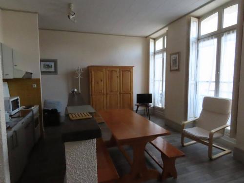 - un salon avec une table en bois, des chaises et des fenêtres dans l'établissement Studio 4 pers centre-ville avec lave-vaisselle à Cauterets - FR-1-234-287, à Cauterets