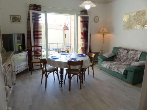 un salon avec une table, des chaises et un canapé dans l'établissement Appartement Climatisé au Centre du Lavandou, 3 Chambres avec Balcon, Proche Commodités - FR-1-308-157, au Lavandou