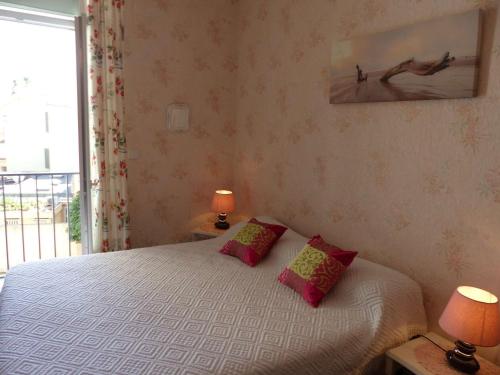 une chambre avec un lit avec deux lampes et une fenêtre dans l'établissement Appartement Climatisé au Centre du Lavandou, 3 Chambres avec Balcon, Proche Commodités - FR-1-308-157, au Lavandou