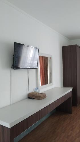 a desk with a television on top of it at PUNCAK VILLAGE HOTEL & KAMPUNG MAIN ANAK in Gadok 1