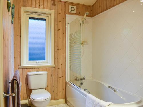 Villa Villekulla في Tirril: حمام به مرحاض وحوض استحمام ونافذة