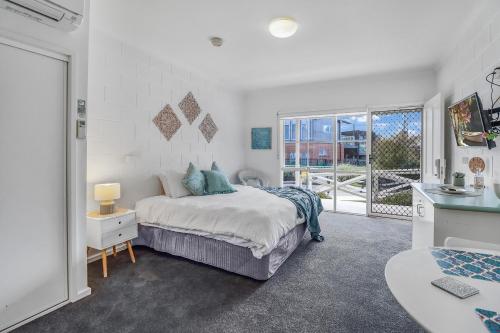 a bedroom with a bed and a large window at Geelong CBD Accommodation in Geelong