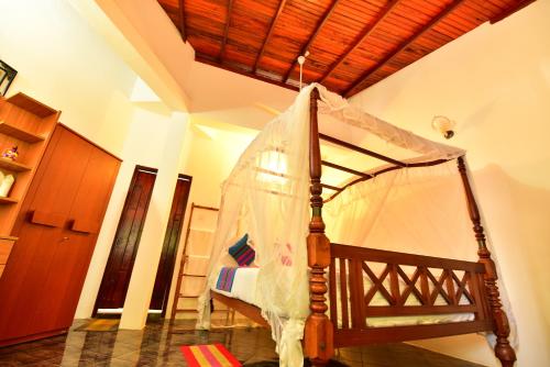 a bedroom with a bed with a mosquito net at Peacock Beach Hotel Unawatuna in Unawatuna