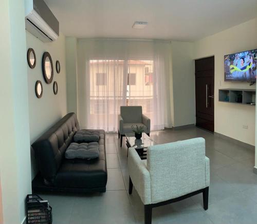 sala de estar con sofá y silla en Garzota Suites Gardens, en Guayaquil