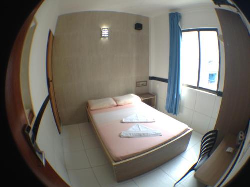 a small room with a bed and a mirror at Hotel Pousada da Praia in Recife