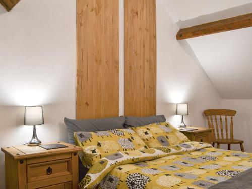 a bedroom with a bed with a wooden headboard at The Old Back Kitchen At Bonfield Ghyll Farm in Chop Gate