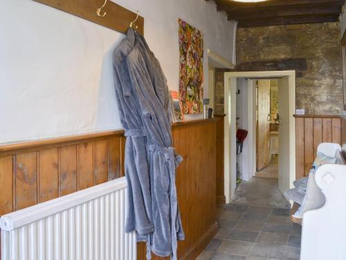 a blue towel hanging on the wall of a bathroom at The Old Back Kitchen At Bonfield Ghyll Farm in Chop Gate