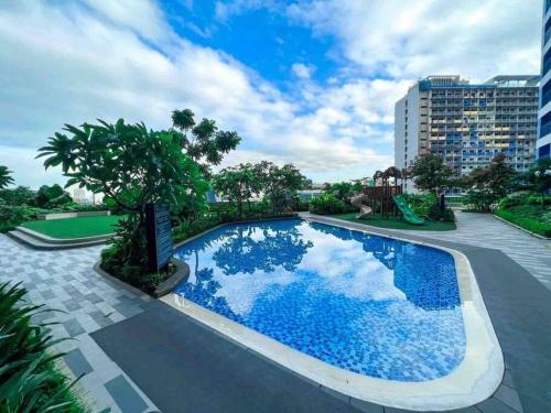 a swimming pool with blue water in a resort at Air Residences - 1Bedroom Unit with Balcony - Wifi & Netflix in Manila