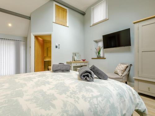a bedroom with a large bed and a flat screen tv at Cwm Dulas in Llanddewi-Brefi