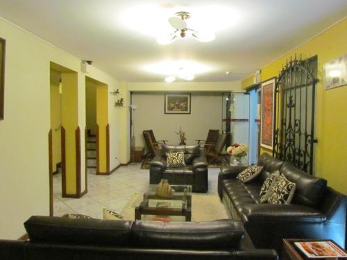 a living room with black leather couches at Samana Hotel in Arequipa