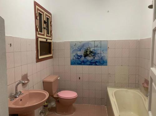 uma casa de banho com um WC cor-de-rosa e um lavatório. em شقة مصيف قريبة للبحر في ميامي em Alexandria