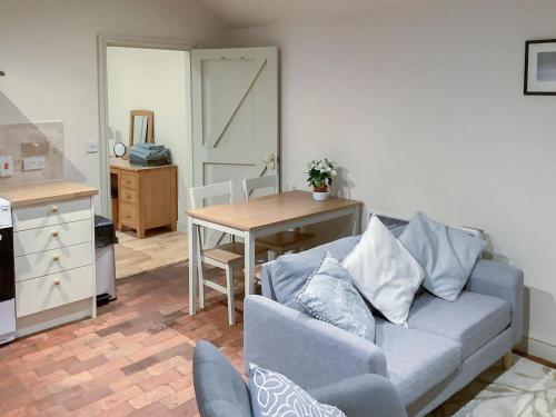 a living room with a couch and a table at Bramble Cottage in Ingoldisthorpe