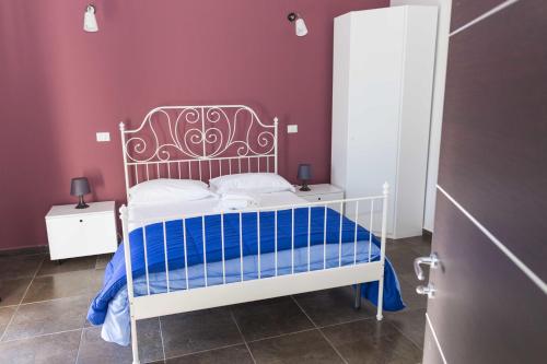a bedroom with a white bed with a purple wall at Hotel Ascot in Caianello