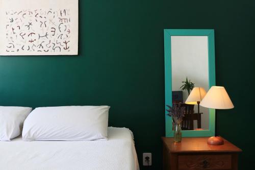 Dormitorio verde con cama y espejo en GayFriendly Hostel BSB Airport, en Brasilia