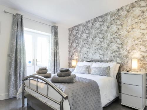 a bedroom with a bed with a floral accent wall at No 2 Railway Cuttings - Uk3402 in Falstone