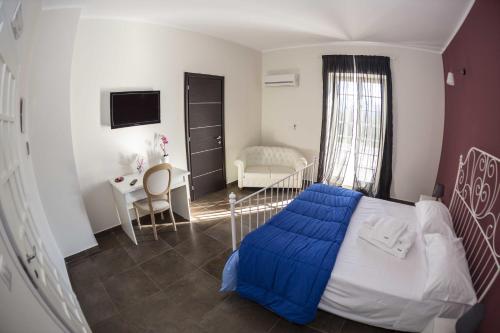 a bedroom with a bed with a blue blanket on it at Hotel Ascot in Caianello