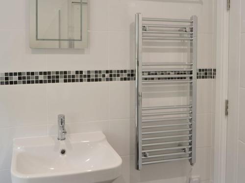 Baño blanco con lavabo y espejo en No 2 Railway Cuttings - Uk3402 en Falstone
