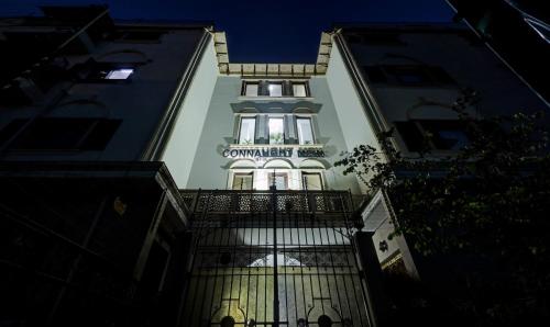a tall white building with a sign on it at Itsy Hotels Connaught Mews in New Delhi