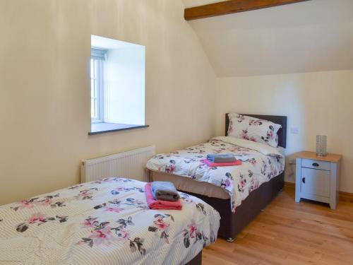 a bedroom with two beds and a window at Stabal Rhoswen in Ffestiniog