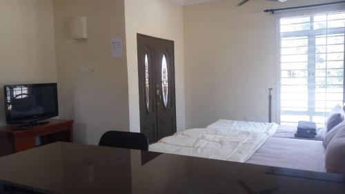 a bedroom with a bed and a tv and a window at GLG KLIA Transit House in Sepang