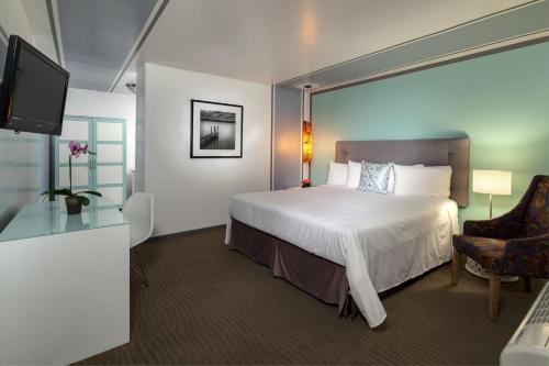a hotel room with a bed and a tv at Aqua Soleil Hotel and Mineral Water Spa in Desert Hot Springs